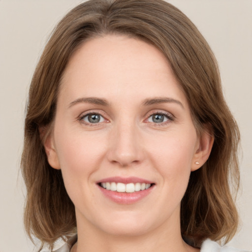 Joyful white young-adult female with medium  brown hair and green eyes