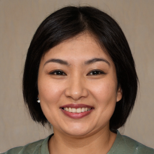 Joyful asian young-adult female with medium  brown hair and brown eyes