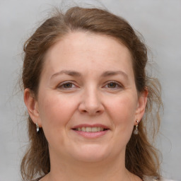 Joyful white young-adult female with medium  brown hair and grey eyes