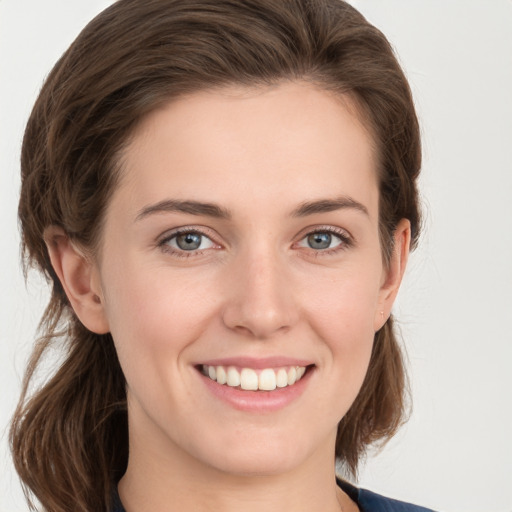 Joyful white young-adult female with medium  brown hair and grey eyes