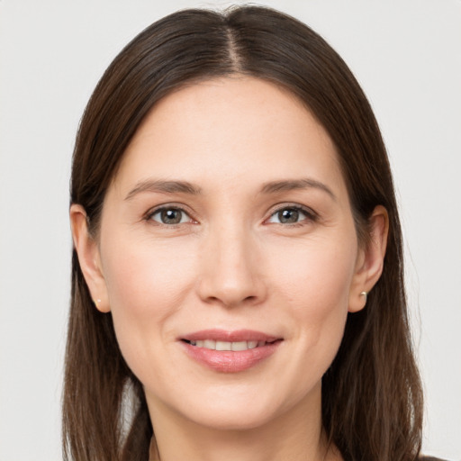 Joyful white young-adult female with long  brown hair and grey eyes