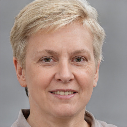 Joyful white middle-aged female with short  blond hair and grey eyes