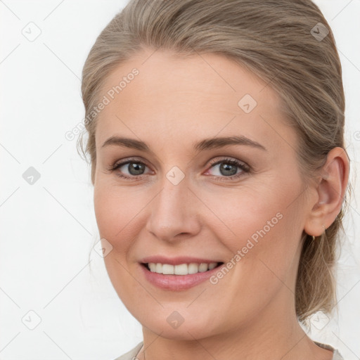 Joyful white young-adult female with medium  brown hair and grey eyes