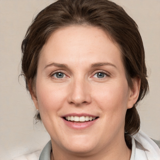 Joyful white adult female with medium  brown hair and grey eyes