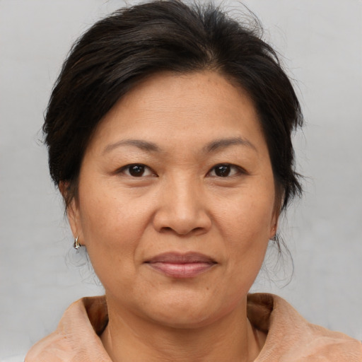 Joyful asian adult female with medium  brown hair and brown eyes