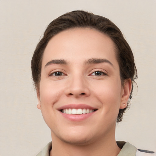 Joyful white young-adult female with short  brown hair and brown eyes