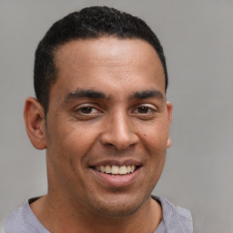 Joyful latino young-adult male with short  brown hair and brown eyes