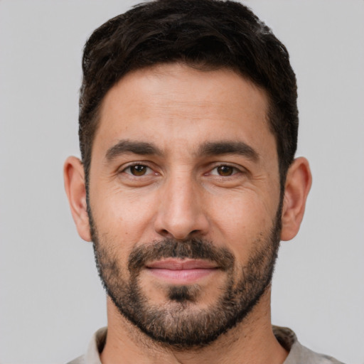 Joyful white young-adult male with short  black hair and brown eyes