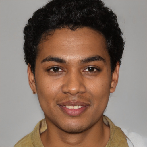 Joyful black young-adult male with short  black hair and brown eyes