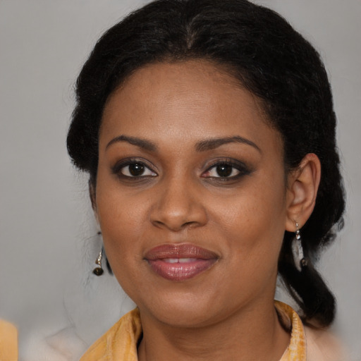 Joyful black adult female with medium  brown hair and brown eyes