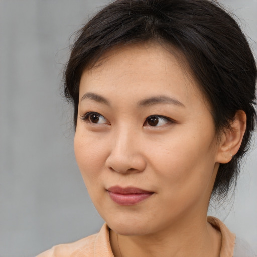 Joyful asian young-adult female with medium  brown hair and brown eyes
