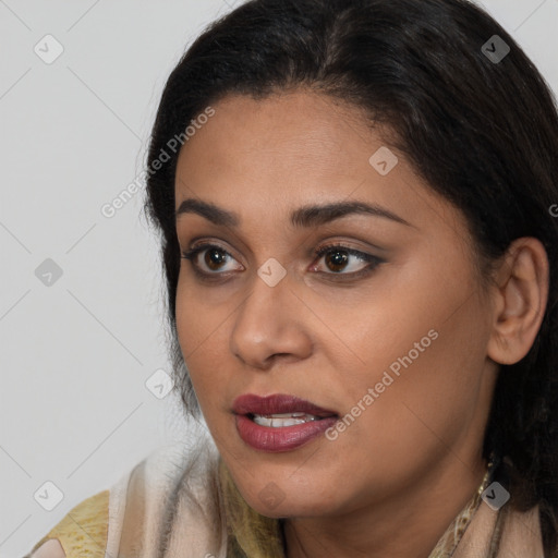 Joyful black young-adult female with long  brown hair and brown eyes