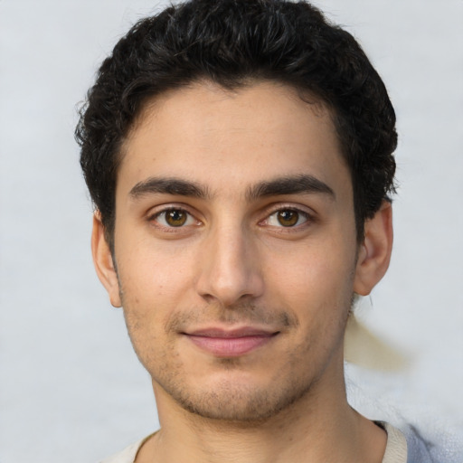 Joyful latino young-adult male with short  brown hair and brown eyes