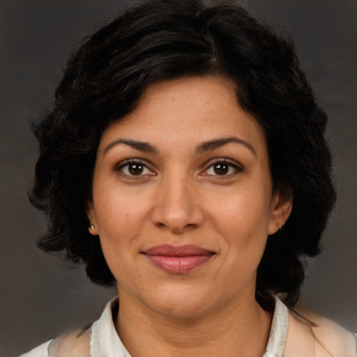Joyful latino adult female with medium  brown hair and brown eyes