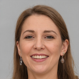 Joyful white adult female with long  brown hair and grey eyes