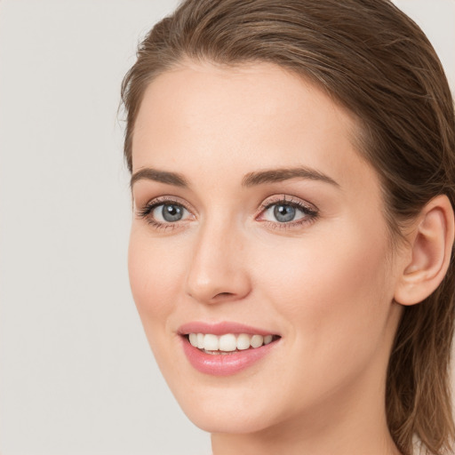 Joyful white young-adult female with long  brown hair and blue eyes