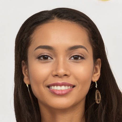 Joyful latino young-adult female with long  brown hair and brown eyes