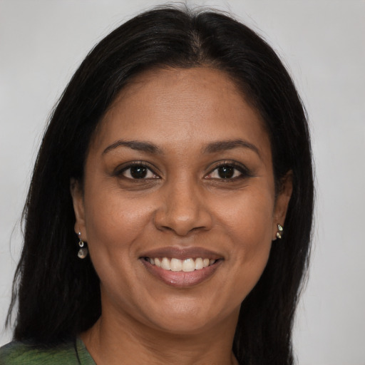 Joyful black adult female with long  brown hair and brown eyes