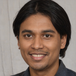 Joyful latino young-adult male with short  black hair and brown eyes