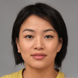 Joyful asian young-adult female with medium  brown hair and brown eyes