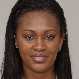 Joyful black adult female with long  brown hair and brown eyes