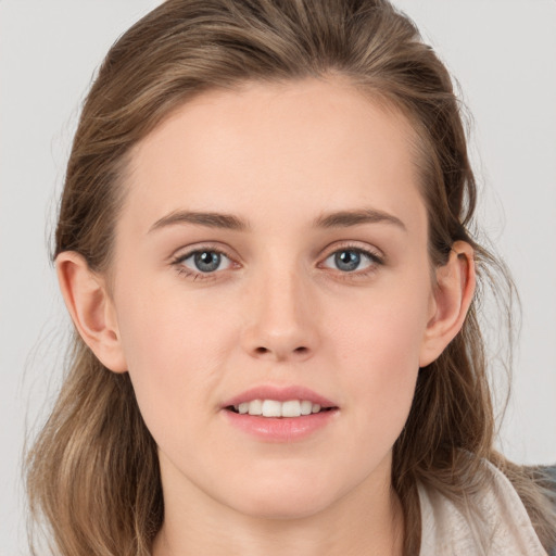 Joyful white young-adult female with long  brown hair and grey eyes