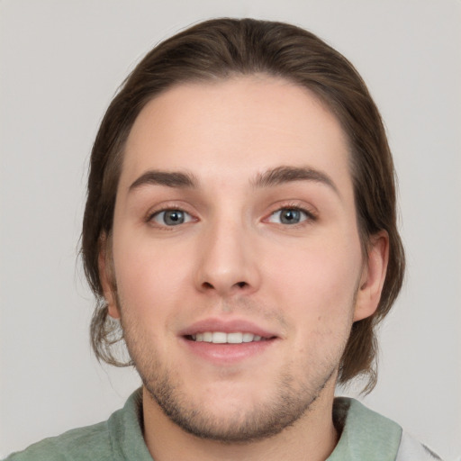 Joyful white young-adult male with medium  brown hair and grey eyes