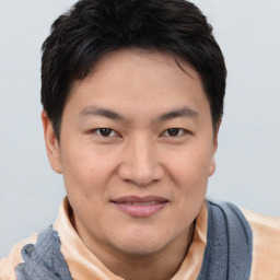 Joyful asian young-adult male with short  brown hair and brown eyes