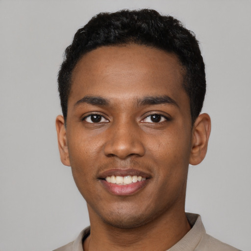 Joyful black young-adult male with short  black hair and brown eyes