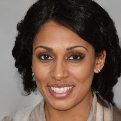 Joyful black adult female with long  black hair and brown eyes