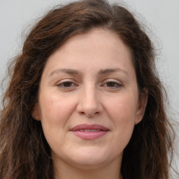 Joyful white adult female with long  brown hair and brown eyes