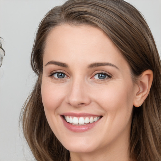 Joyful white young-adult female with long  brown hair and brown eyes