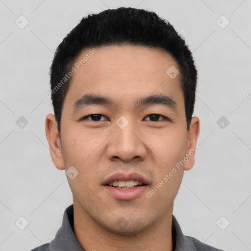 Joyful asian young-adult male with short  black hair and brown eyes