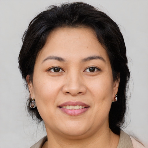 Joyful asian adult female with medium  brown hair and brown eyes