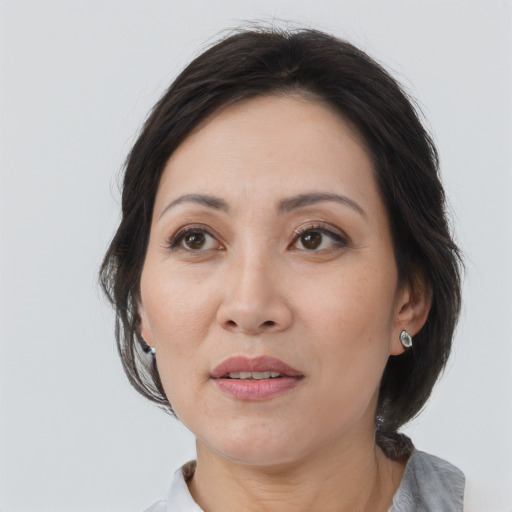 Joyful asian adult female with medium  brown hair and brown eyes