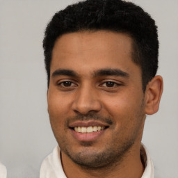 Joyful latino young-adult male with short  black hair and brown eyes