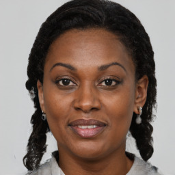 Joyful black young-adult female with medium  brown hair and brown eyes