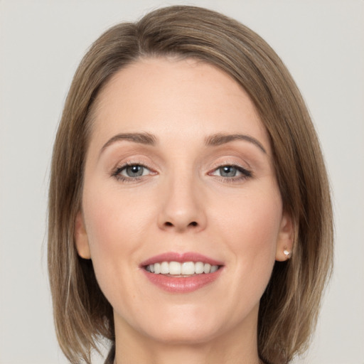 Joyful white young-adult female with medium  brown hair and grey eyes