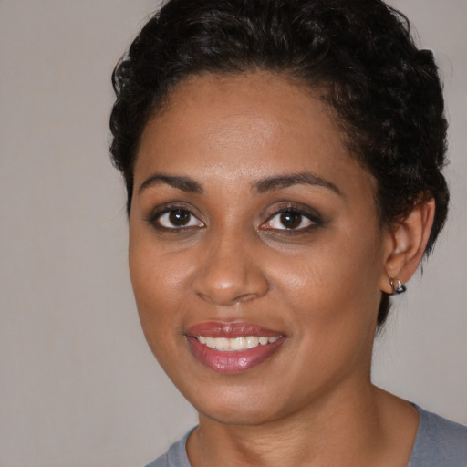 Joyful black young-adult female with short  brown hair and brown eyes
