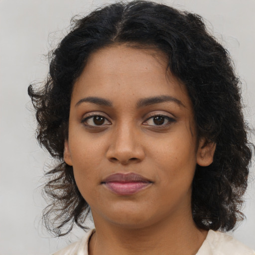 Joyful black young-adult female with medium  brown hair and brown eyes