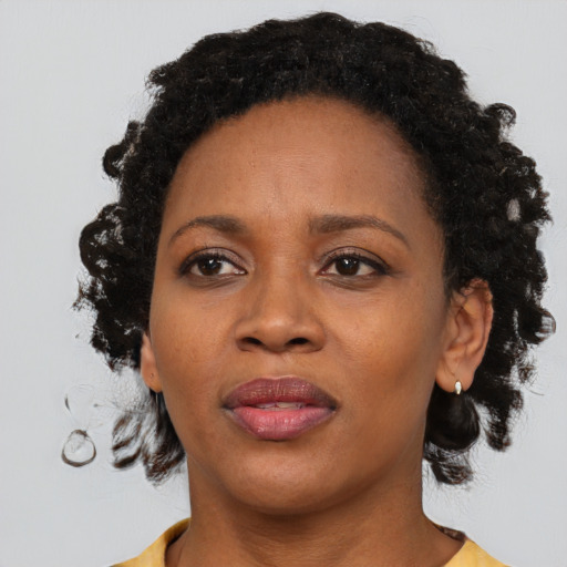 Joyful black adult female with medium  brown hair and brown eyes