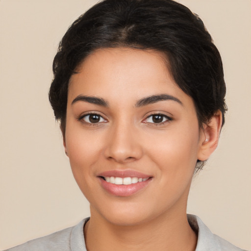 Joyful latino young-adult female with short  black hair and brown eyes