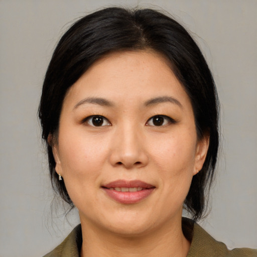 Joyful asian adult female with medium  brown hair and brown eyes