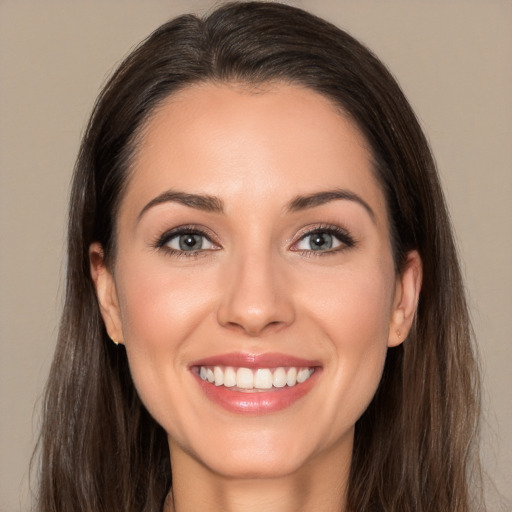 Joyful white young-adult female with long  brown hair and brown eyes