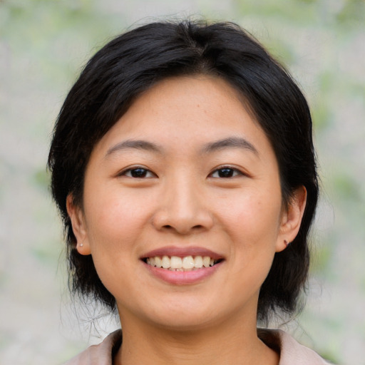 Joyful asian young-adult female with medium  brown hair and brown eyes