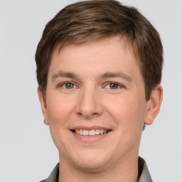 Joyful white young-adult male with short  brown hair and grey eyes