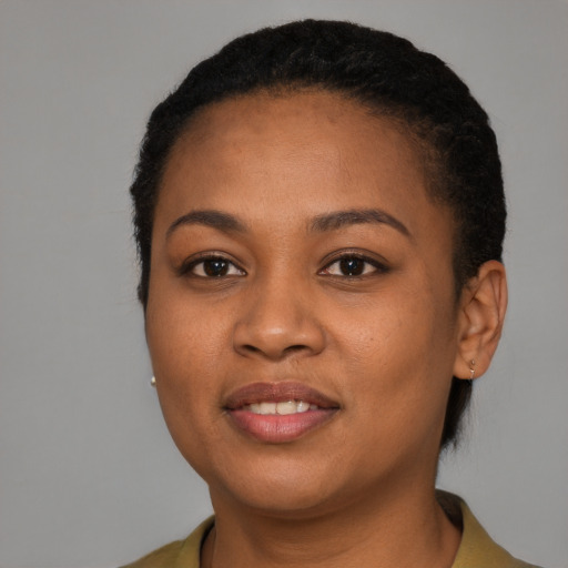 Joyful black young-adult female with short  black hair and brown eyes