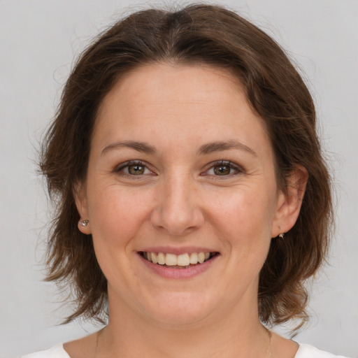 Joyful white adult female with medium  brown hair and brown eyes