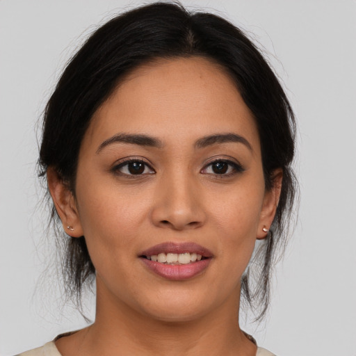 Joyful latino young-adult female with medium  brown hair and brown eyes