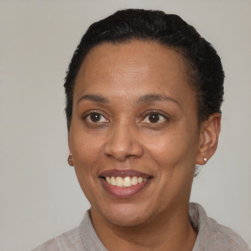 Joyful black adult female with short  black hair and brown eyes